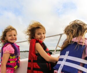 three kids on a boat